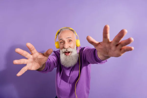 Retrato de atractivo hombre de pelo gris alegre escuchando música que le toca divertirse aislado sobre violeta violeta fondo de color — Foto de Stock