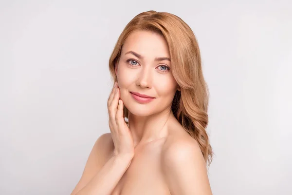 Photo portrait woman after shower smiling with nude shoulders applying cream on cheeks isolated white color background copyspace — Stock Photo, Image