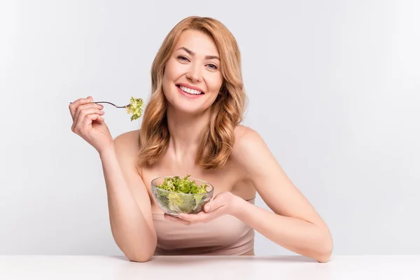 Porträt einer attraktiven, fröhlichen Frau, die veganen Salat isst, fit für Sport, isoliert über grauem Pastell — Stockfoto