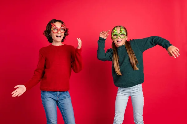 Portrait of two attractive carefree cheerful friends dancing having fun rest day isolated over bright red color background — Stock Photo, Image