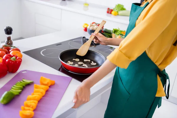 Foto di bella attraente donna pelle scura vestita camicia gialla cucinare funghi all'interno della casa home room — Foto Stock