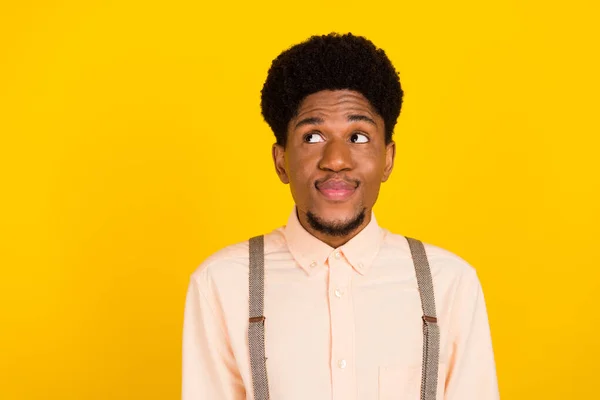 Foto de sonho tímido namorado cara procurar espaço vazio desgaste suspensórios camisa isolado cor amarela fundo — Fotografia de Stock