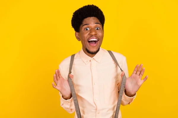 Foto de tipo africano alegre loco funky humor juguetón desgaste tirantes camisa aislado color amarillo fondo — Foto de Stock