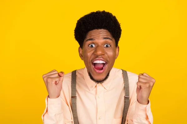 Foto portret man in shirt bretels gebaren als winnaar dolblij geïsoleerde levendige gele kleur achtergrond — Stockfoto