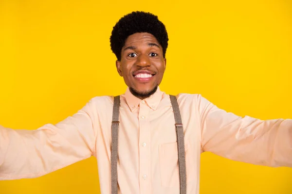 Foto retrato homem na camisa sorrindo feliz tirando selfie na câmera isolado vibrante cor amarela fundo — Fotografia de Stock