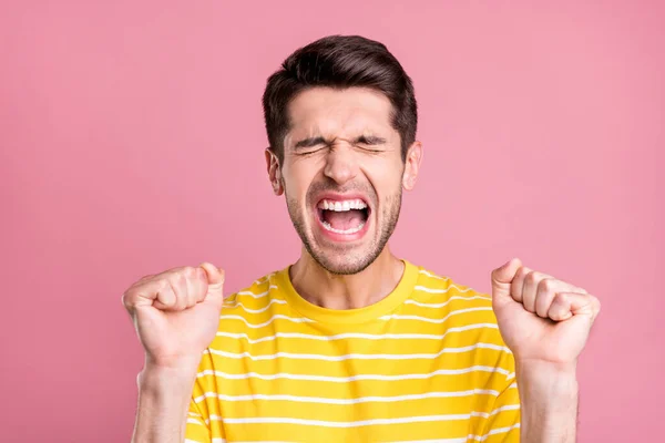 Portret van aantrekkelijke dromerige vrolijke jongen vieren plezier geweldig nieuws geïsoleerd over roze pastel kleur achtergrond — Stockfoto