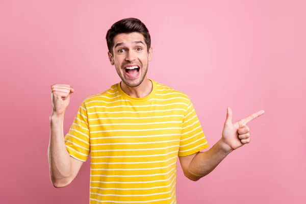 Foto van hooray brunet jonge man punt lege ruimte dragen geel t-shirt geïsoleerd op roze kleur achtergrond — Stockfoto