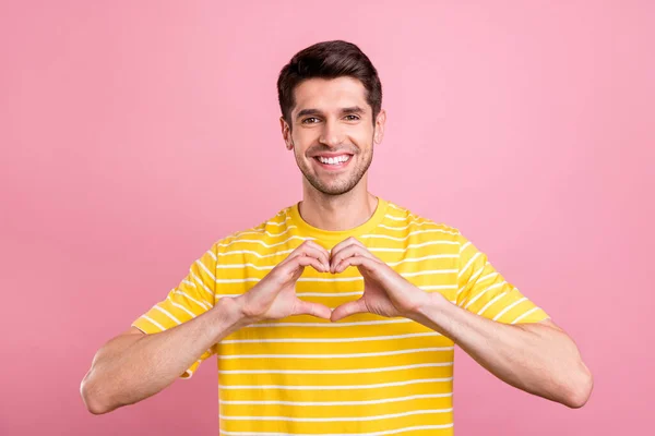 Fotografie pozitivního mladého šťastného muže, aby prsty srdce tvar náklonnost láska izolované na růžovém pozadí — Stock fotografie