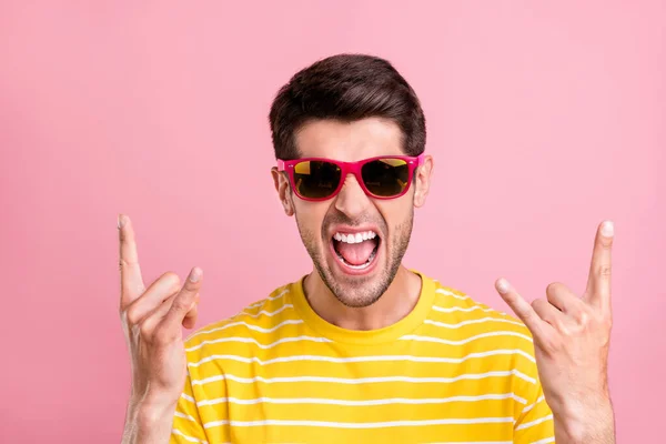 Portret atrakcyjny niegrzeczny szalony wesoły facet pokazując znak róg zabawy izolowane nad różowy pastelowy kolor tła — Zdjęcie stockowe