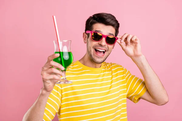 Foto de homem alegre encantador feliz segurar cheers cocktail usar vidro solar isolado no fundo cor-de-rosa — Fotografia de Stock