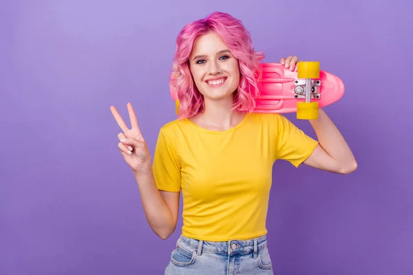Φωτογραφία του νεαρού ελκυστικό κορίτσι ευτυχής θετικό χαμόγελο δείχνουν νίκη v-σημάδι κρατήσει longboard απομονώνονται πάνω από μωβ φόντο χρώμα — Φωτογραφία Αρχείου
