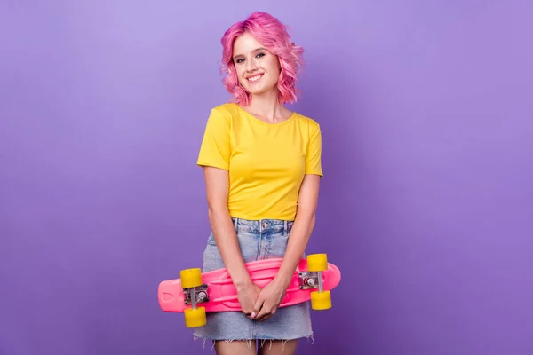 Foto de menina alegre feliz sorriso positivo esporte skate hobby isolado sobre cor roxa fundo — Fotografia de Stock