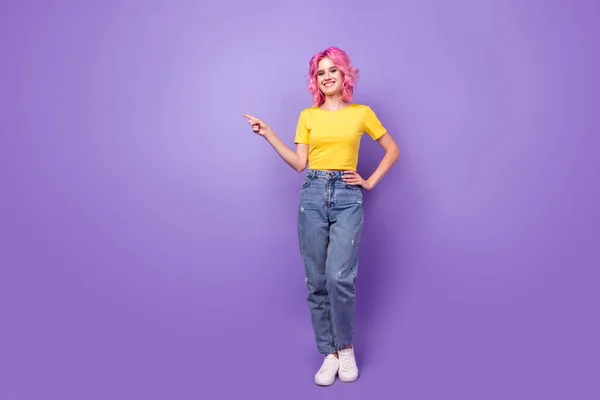 Foto de cuerpo completo de niña feliz sonrisa positiva dedo vacío espacio anuncios sugieren la venta aislado sobre fondo de color violeta — Foto de Stock