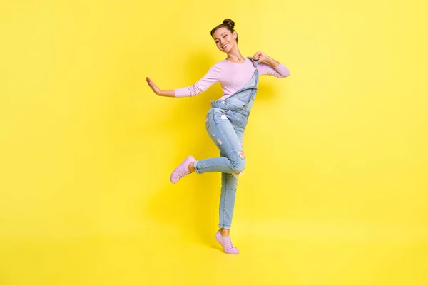 Foto de despreocupado clubber senhora stand tiptoe dança beaming branco sorriso desgaste jeans geral sapatos isolados fundo amarelo — Fotografia de Stock