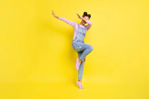 Foto av rolig söt dam stå tå dans gör dub flytta bära jeans övergripande sneakers isolerad gul bakgrund — Stockfoto