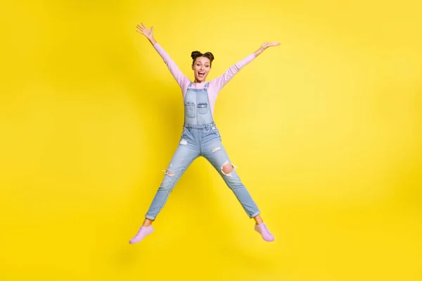Foto de la señora linda emocionada salto estrella forma levantar las manos boca abierta usar jeans zapatos generales aislados fondo amarillo — Foto de Stock