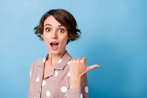 Foto des jungen Mädchens erstaunt überrascht zeigen Daumen leer Leerzeichen Wahl Werbung isoliert über blauem Hintergrund — Stockfoto