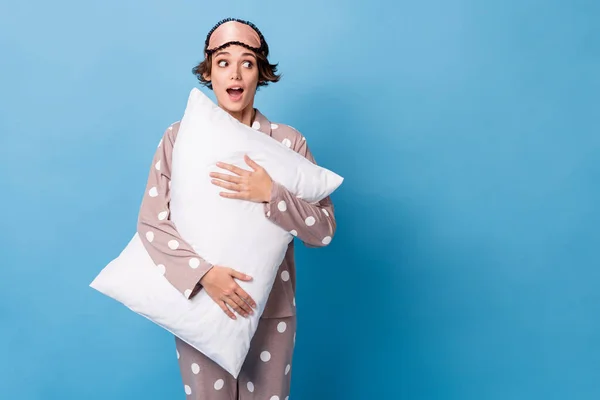 Photo of young excited girl amazed surprise look empty space hug pillow isolated over blue color background — Stock Photo, Image