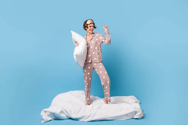 Foto de cuerpo completo de la joven excitada feliz sonrisa positiva regocijarse divertirse pijamas partido aislado sobre fondo de color azul —  Fotos de Stock