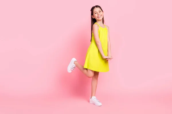 Fotografie okouzlující sladké malé školačky oblečené žlutý outfit tanec chůze s úsměvem izolované růžové barvy pozadí — Stock fotografie