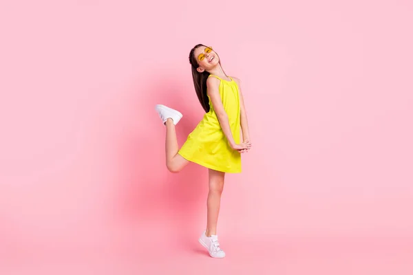 Full length photo of pretty charming schoolgirl dressed yellow outfit dark glasses dancing smiling isolated pink color background — Stock Photo, Image