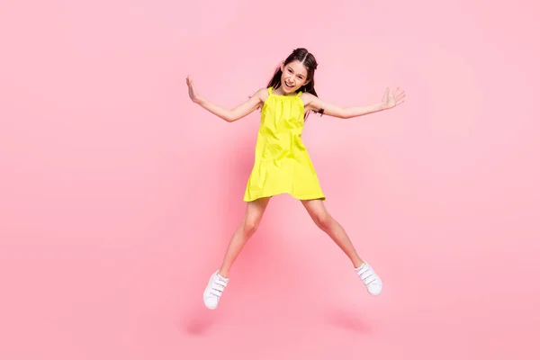 Foto de comprimento total de adorável colegial bonita vestida roupa amarela óculos escuros saltando alto sorrindo isolado cor de fundo rosa — Fotografia de Stock