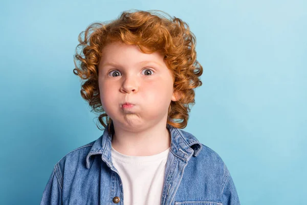 Photo de jeu stupide drôle petit garçon gonflé joues gonflées porter une veste en denim isolé fond de couleur bleue — Photo