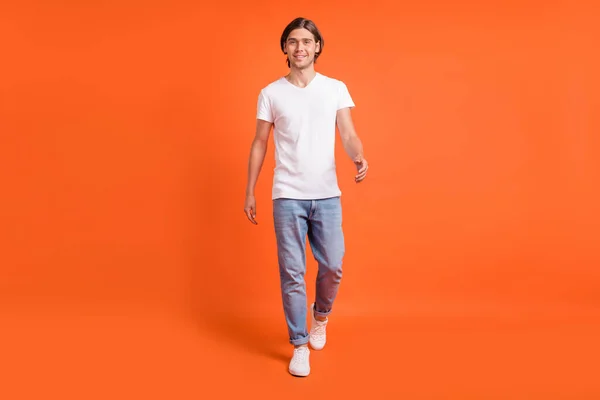 Full size foto van charmante aantrekkelijke vrolijke man lopen goed humeur te dragen casual kleding geïsoleerd op oranje kleur achtergrond — Stockfoto