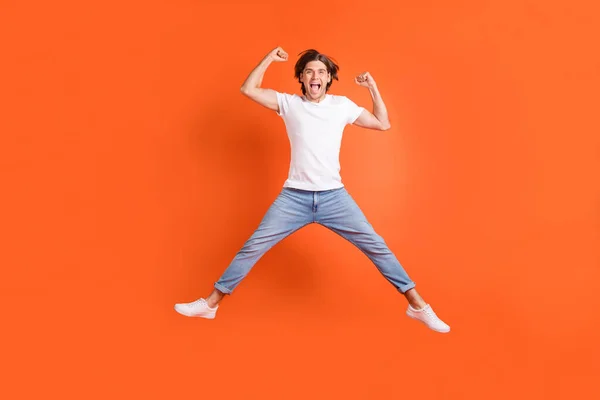 Pleine photo du corps de heureux homme fou joyeux sauter gagnant célébrer isolé sur fond de couleur orange — Photo