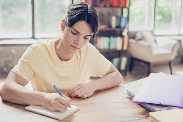 Retrato de atraente focado cara escrevendo ensaio lista fazendo lição de casa preparando exame de teste acadêmico dentro de casa — Fotografia de Stock