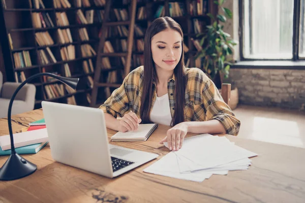 Foto di giovane bella ragazza concentrata tranquilla studente universitario si preparano per la prova di esame di lettura documenti di studio con il computer portatile al chiuso — Foto Stock