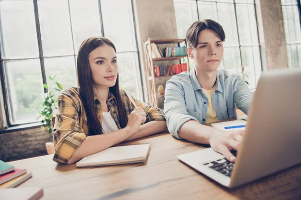 Foto de dos jóvenes personas serias enfocadas estudiantes universitarios buscan información en línea en la computadora portátil prepararse para los exámenes en el interior —  Fotos de Stock