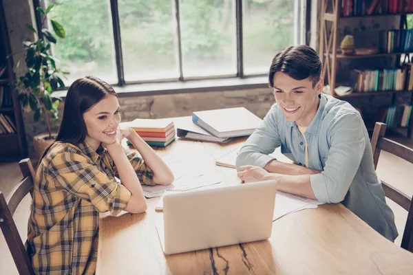 Portret van twee aantrekkelijke vrolijke mensen die binnenshuis webles aan het kijken zijn bij bibliotheek loft industrieel interieur — Stockfoto