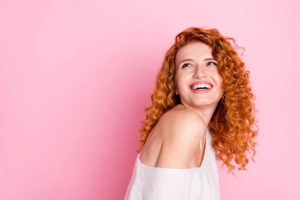 Φωτογραφία πορτρέτο του κόκκινου σγουρά μαλλιά κορίτσι χαμογελά με off-ώμο γέλιο αναζητούν κενό χώρο απομονωμένο παστέλ ροζ χρώμα φόντο — Φωτογραφία Αρχείου