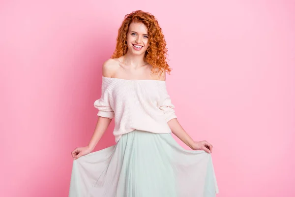 Foto retrato de niña sonriendo feliz mantener falda con ropa elegante aislado pastel de color rosa fondo — Foto de Stock