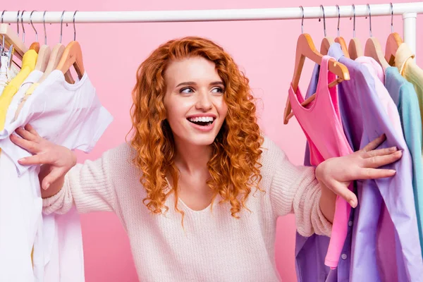 Photo of young excited girl happy positive smile choose clothes store shopping isolated over pink color background