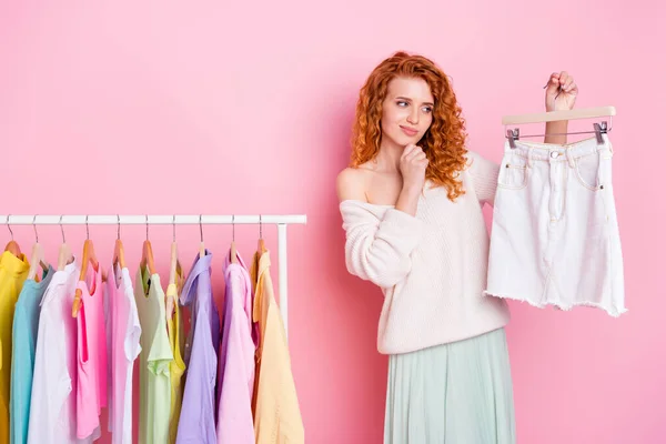 Zdjęcie młodej dziewczyny dotykać podbródek myśleć wybrać strój spódnica sklep izolowane nad pastelowym tle kolor — Zdjęcie stockowe