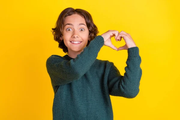 Retrato de cara alegre surpreendente atraente mostrando forma do coração isolado sobre fundo de cor amarelo brilhante — Fotografia de Stock