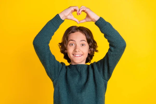 Porträtt av attraktiv glad pojke visar hjärttecken hälso-och sjukvård amour isolerad över ljust gul färg bakgrund — Stockfoto