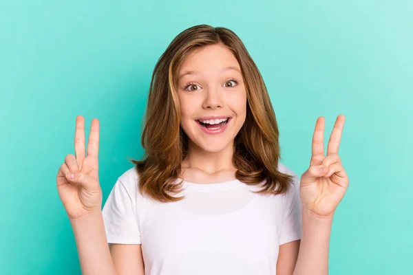 Foto retrato menina sorrindo mostrando v-sinal gesto isolado vibrante cor teal fundo — Fotografia de Stock
