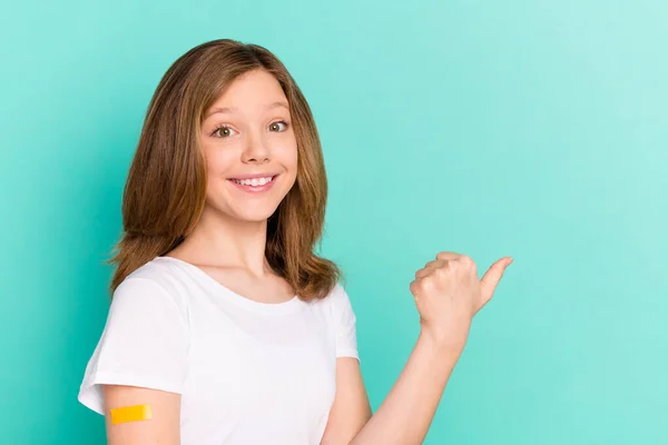 Foto portrét dívka dostala vakcínu z covid-19 ukazující prázdný prostor palec izolované pulzující teal barva pozadí — Stock fotografie