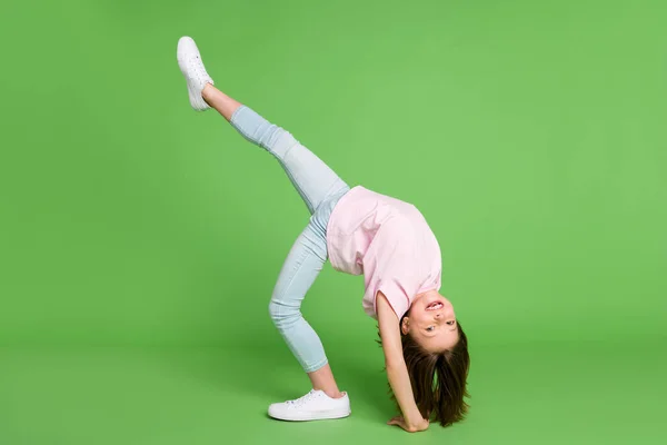 Foto lateral de perfil de longitud completa de la joven niña feliz sonrisa positiva puente flexible aislado sobre fondo de color verde —  Fotos de Stock