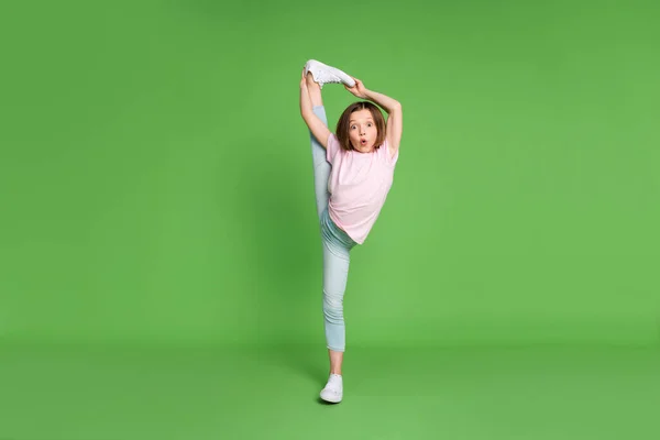 Full storlek foto av ung liten flicka hålla benet stretch split gym motion sport isolerad över grön färg bakgrund — Stockfoto