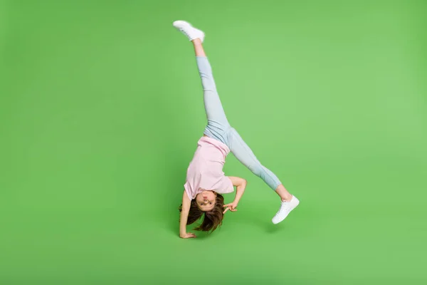 Pleine taille photo de jeune fille handstand équilibre montrer paix cool v-signe isolé sur fond de couleur verte — Photo