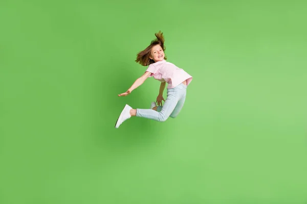 Longitud completa perfil lado de la foto de la joven feliz sonrisa positiva divertirse salto aislado sobre fondo de color verde —  Fotos de Stock