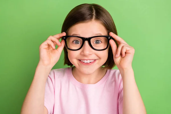 Foto di giovane ragazza eccitata felice sorriso positivo indossare occhiali visione oftalmologia isolato su sfondo di colore verde — Foto Stock