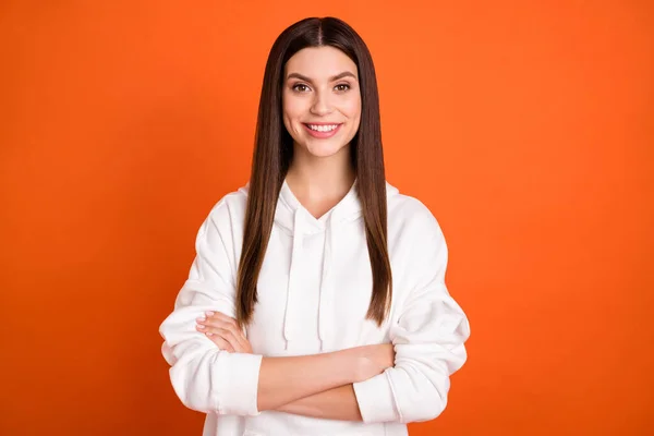 Porträtt av attraktivt innehåll brunett glad flicka vikta armar isolerade över pulserande orange färg bakgrund — Stockfoto