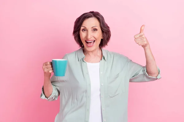 Retrato de pessoas positivas animadas segurar caneca de chá mostrar polegar para cima aprovar sorriso de dente isolado no fundo cor-de-rosa — Fotografia de Stock