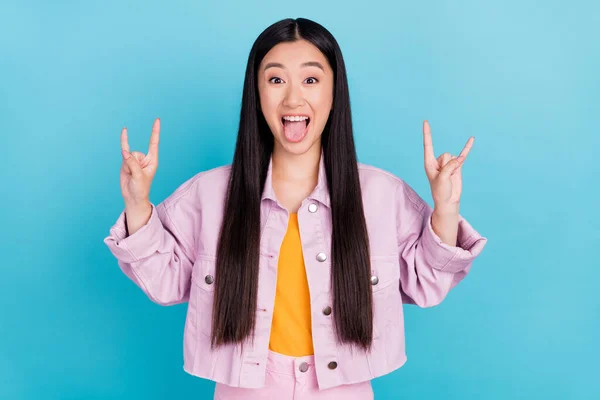 Retrato de chica alegre atractiva mostrando doble signo de cuerno que se divierte aislado sobre fondo de color azul brillante —  Fotos de Stock