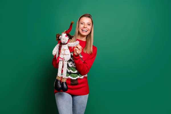 Retrato de menina alegre atraente segurando em mãos brinquedo animal Eve Noel dia isolado sobre fundo de cor verde — Fotografia de Stock